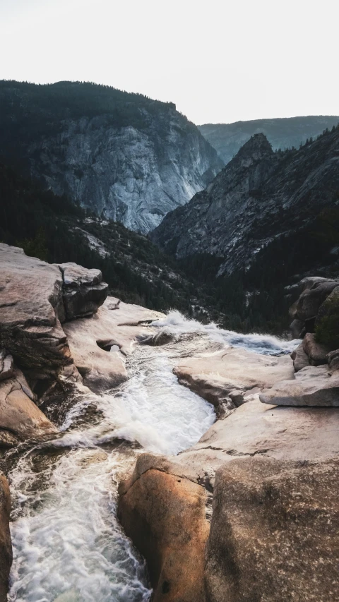 a stream runs through some rocks towards a mountain