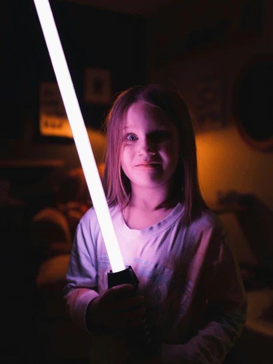 a woman in a dark room holding a light sword