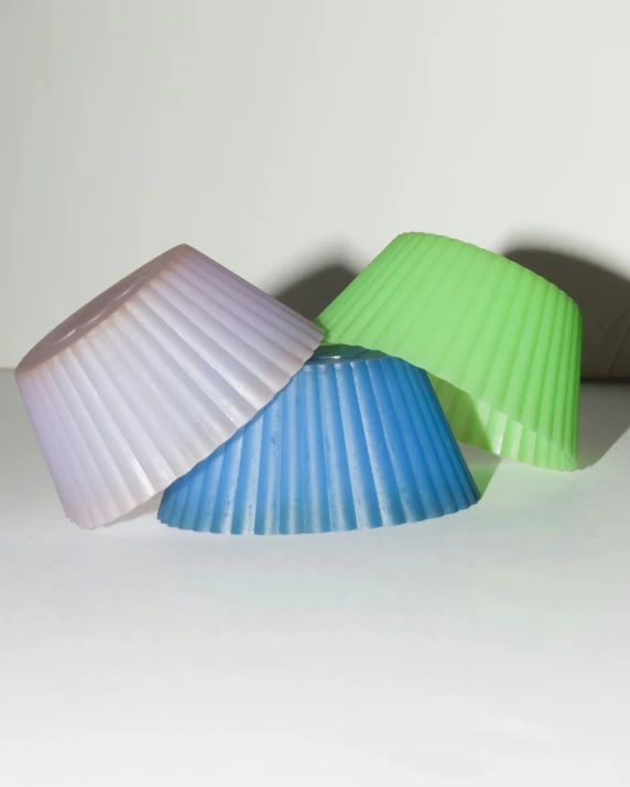 a group of three colorful lamps sitting on a white surface