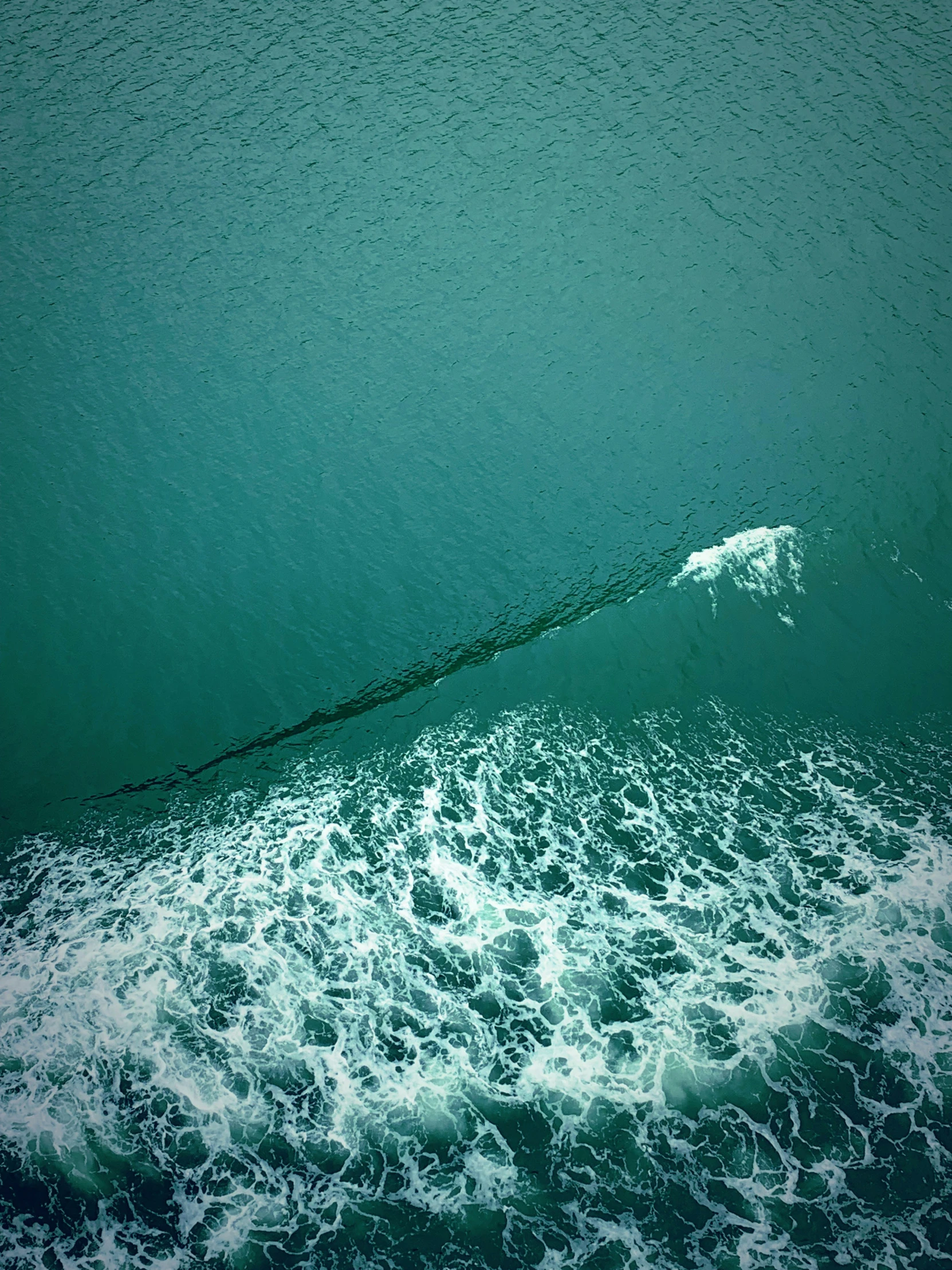 an ocean scene with the wave being crested by a surf board