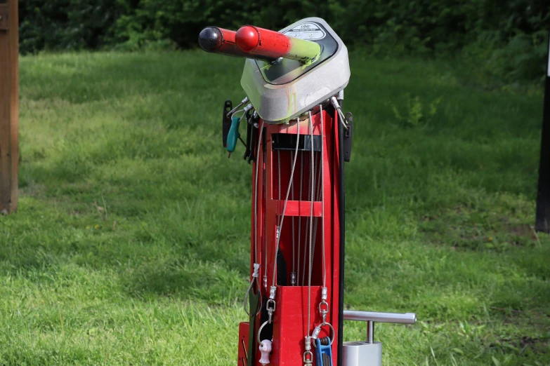 a red piece of luggage and a baseball bat are tied to the pole