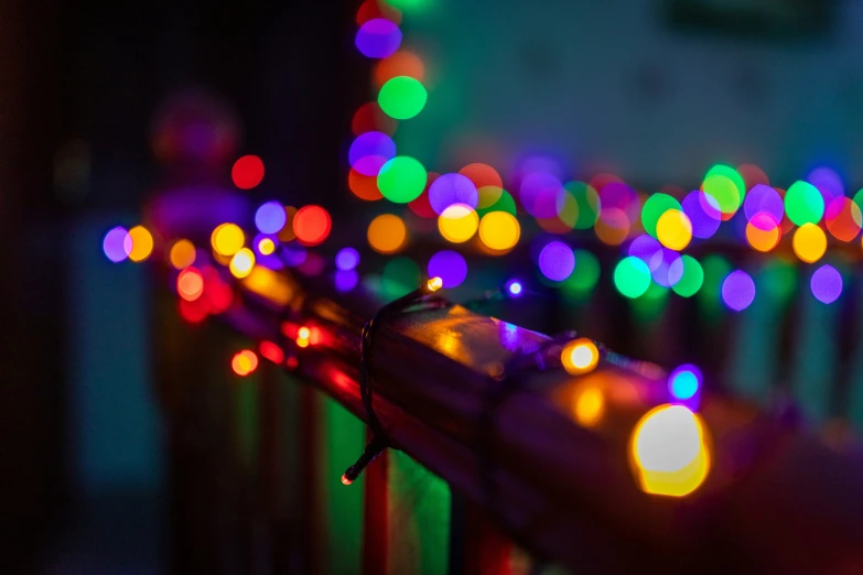 brightly colored lights shine from the top of a metal rail