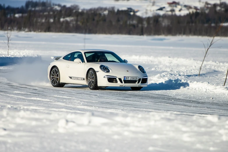 a white porsche parked on a snowy road