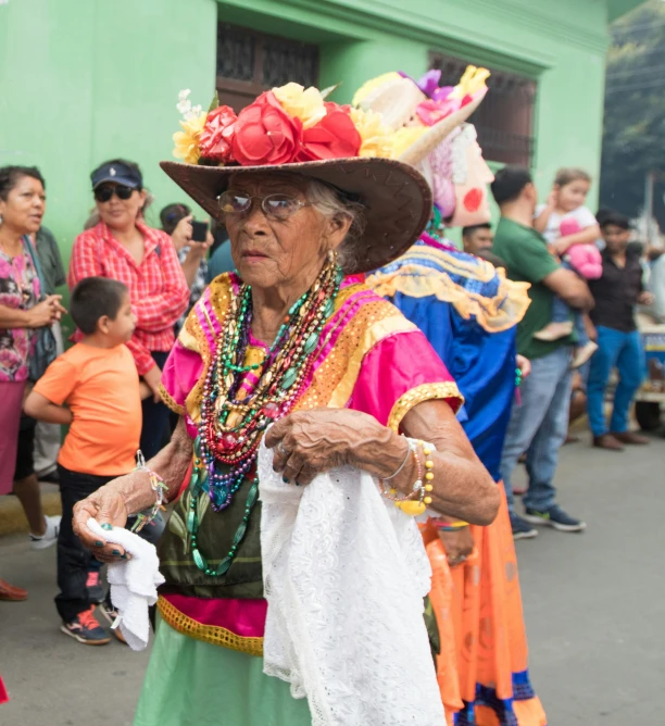 an older woman in colorful outfit carrying a white bag