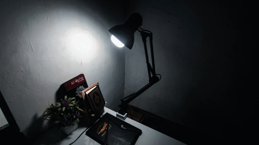 a black lamp, monitor and lamp stand on the wall