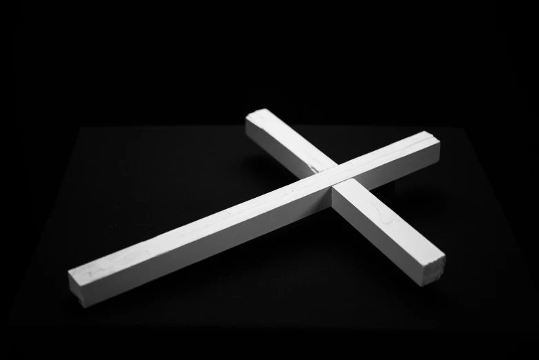 a white wooden object laying on top of a black surface