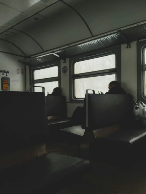 three people are sitting inside a bus or train