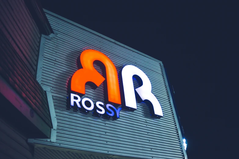 a sign for ross at night on the outside of a building