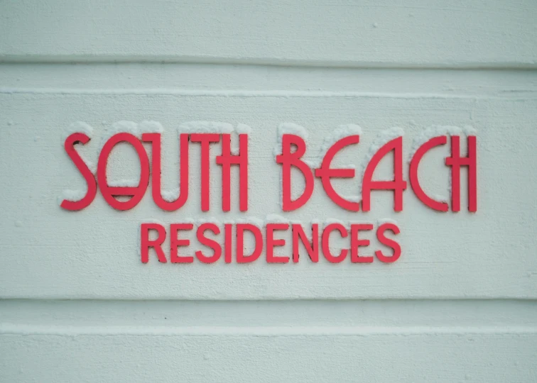 a white sign reads south beach residence on the side of a building