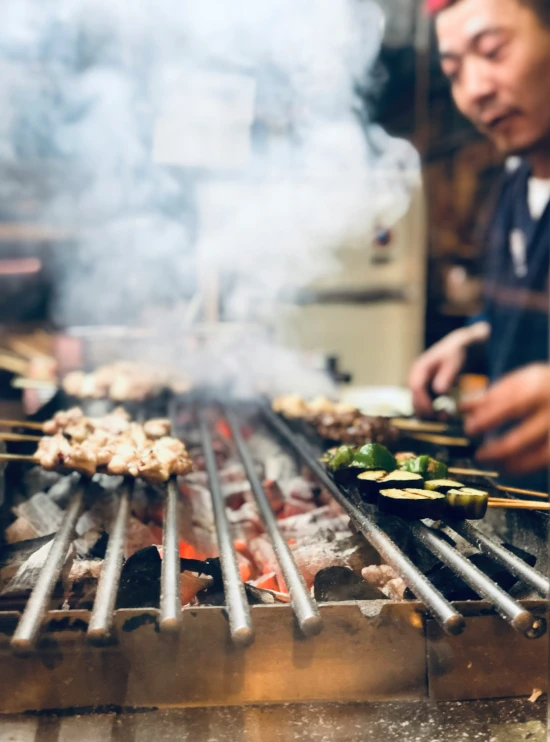 a man cooking food on top of a grill