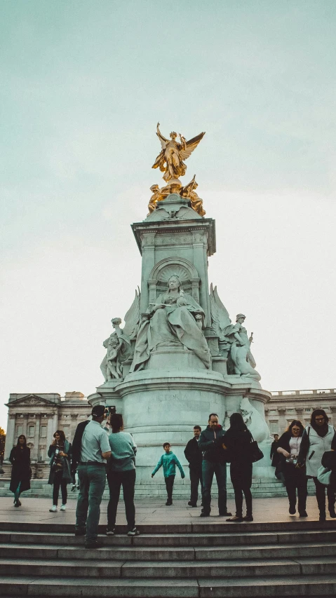 people are walking and sitting around the statue