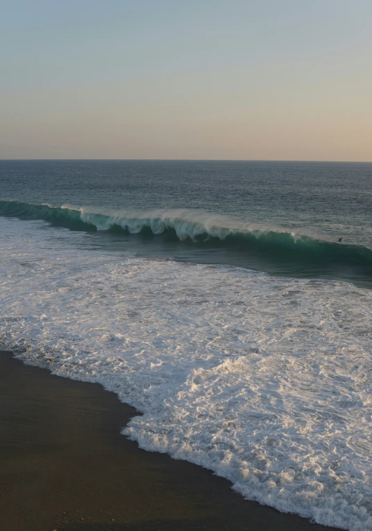 waves crashing against a sandy beach near the ocean