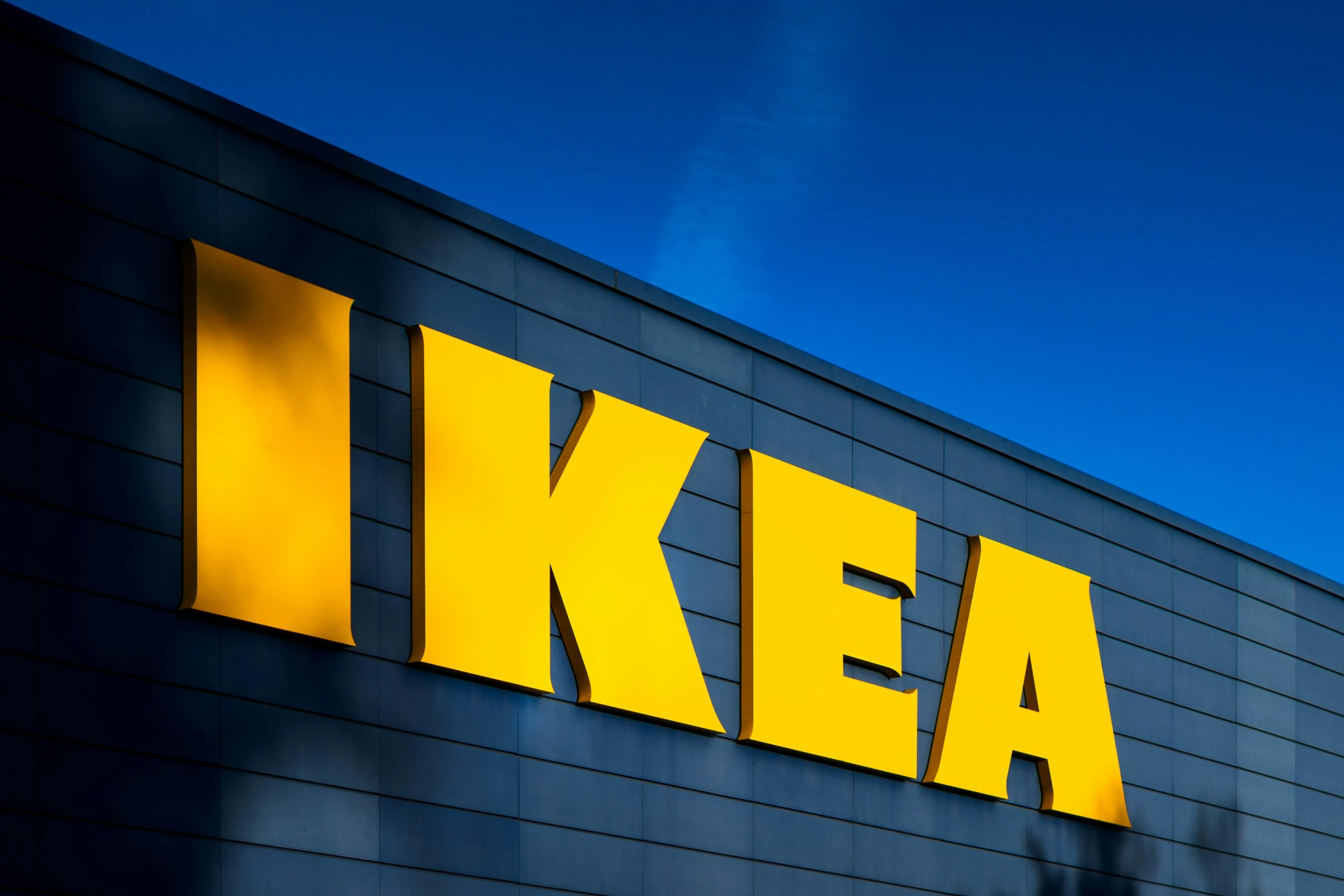 a sign for a large ikea store is lit against the night sky