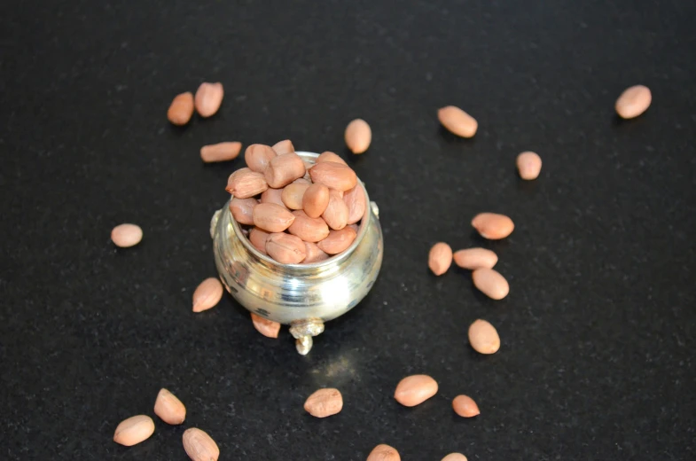 several peanuts scattered around the small glass jar