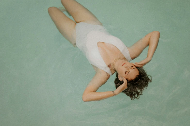 a woman laying on the ground wearing an all white outfit