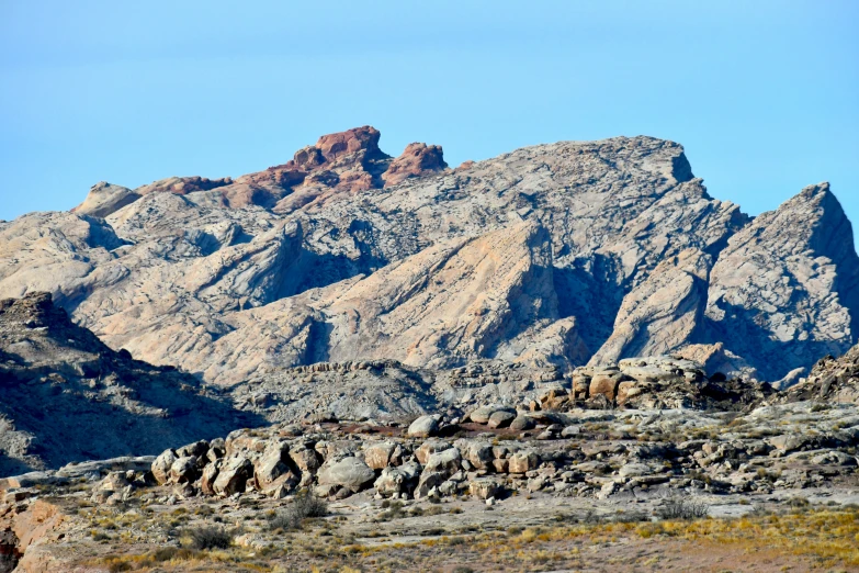 a mountain range covered in rocks under a blue sky