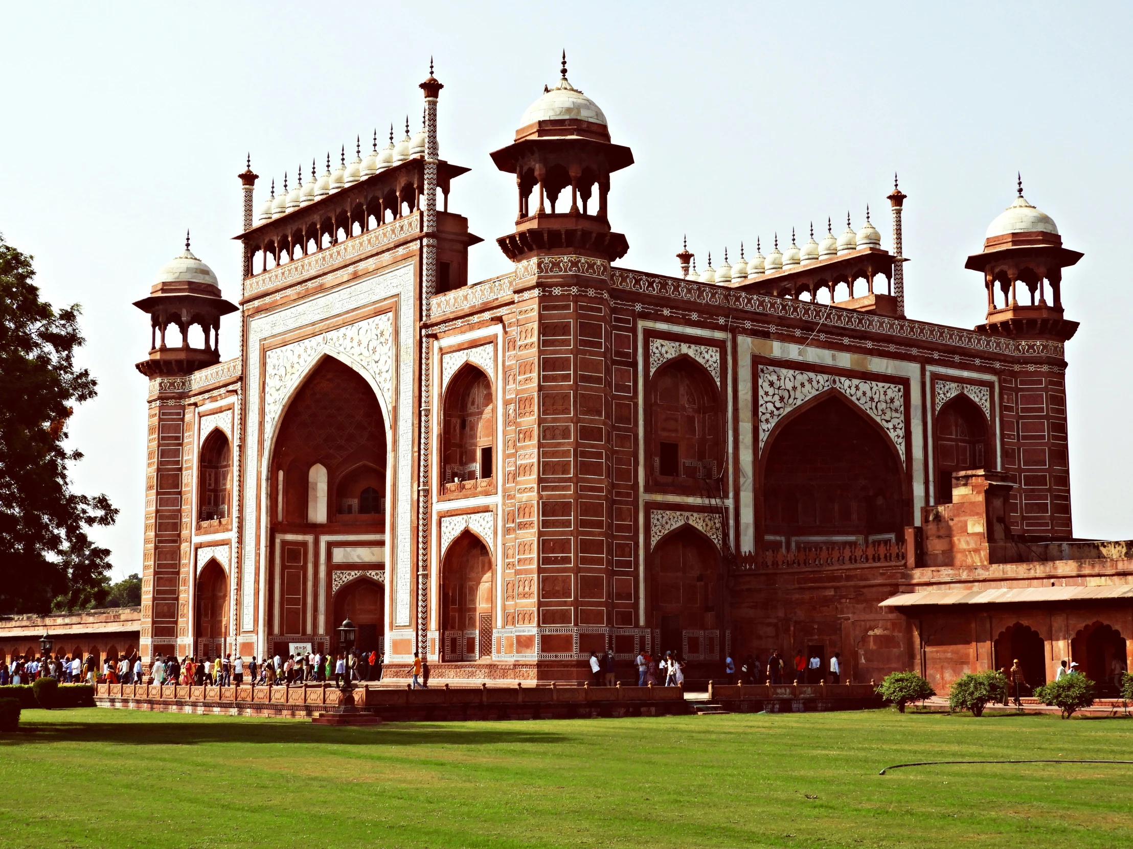 people walking around the large brick building