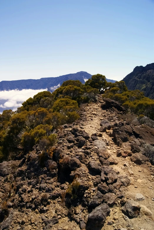 a dirt and stone path winds through a mountainous area