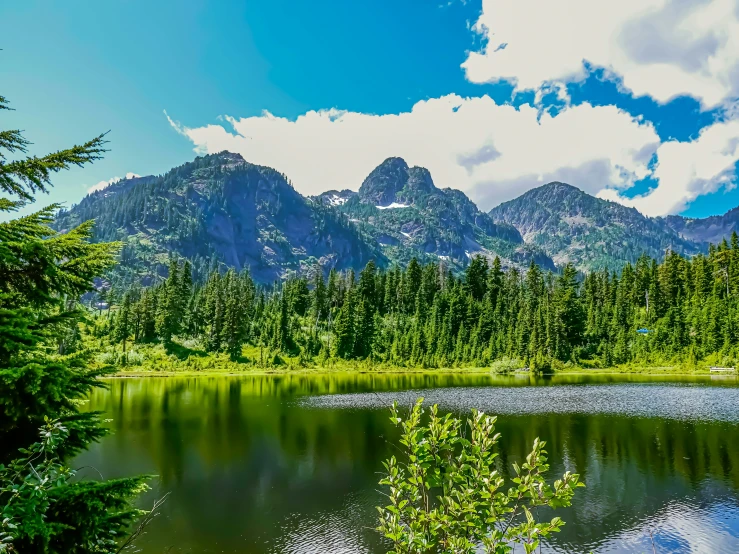 beautiful po of mountains in the distance and still water in the lake