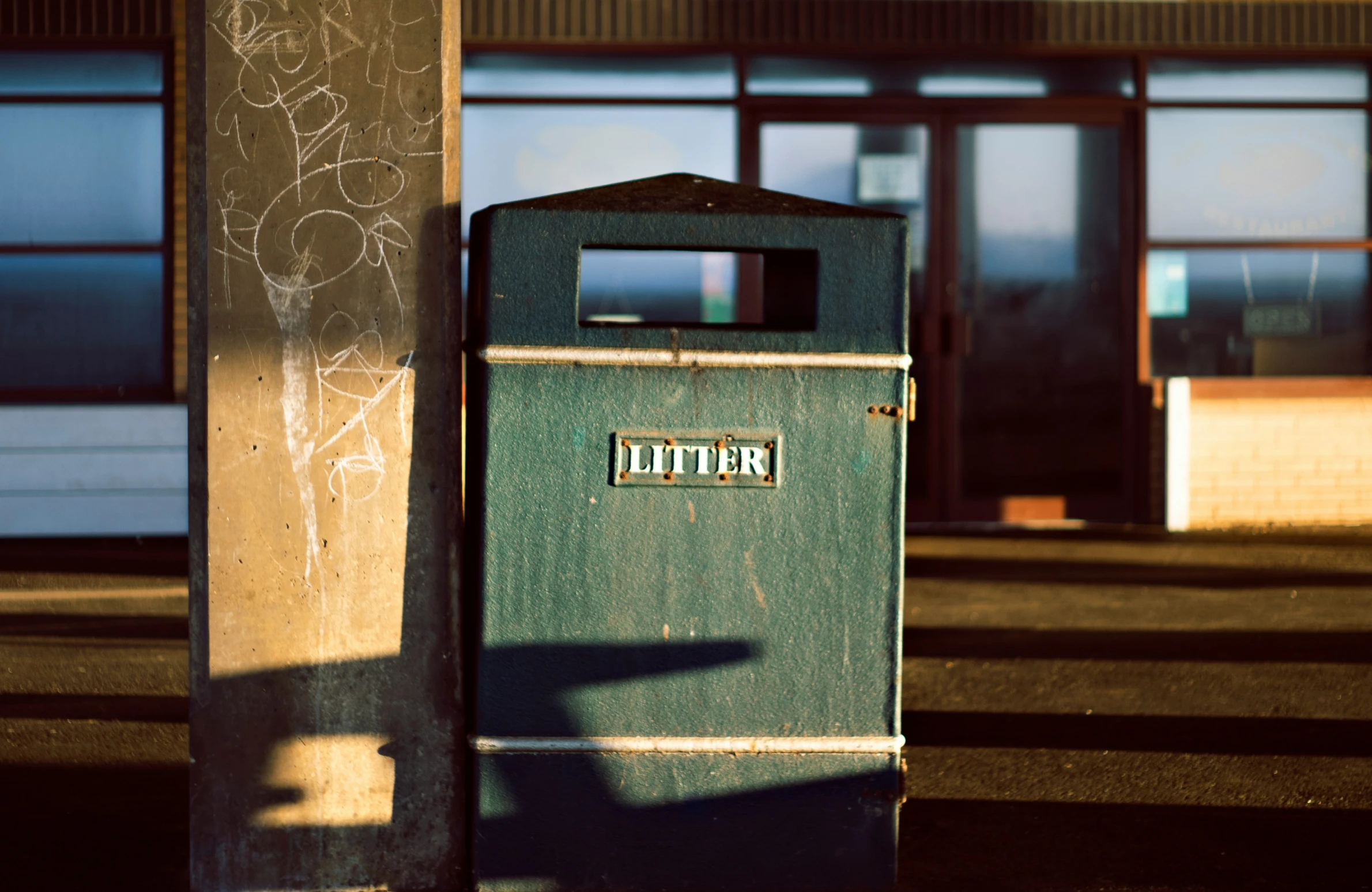 a rusted metal trash bin sitting in the middle of a street