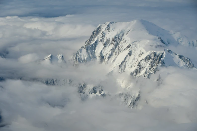 snow covered mountain tops are shown from the sky