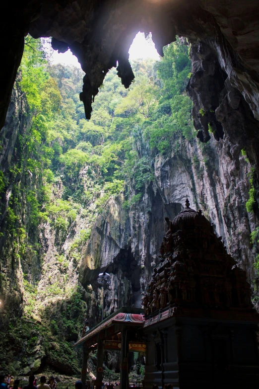 the view from inside a cave looking at a small shrine