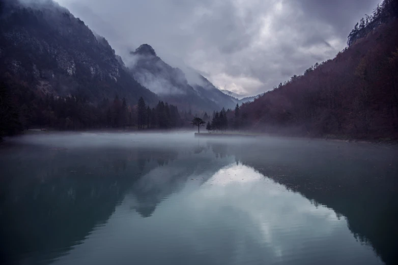 this is a view of a calm lake with a few boats on it