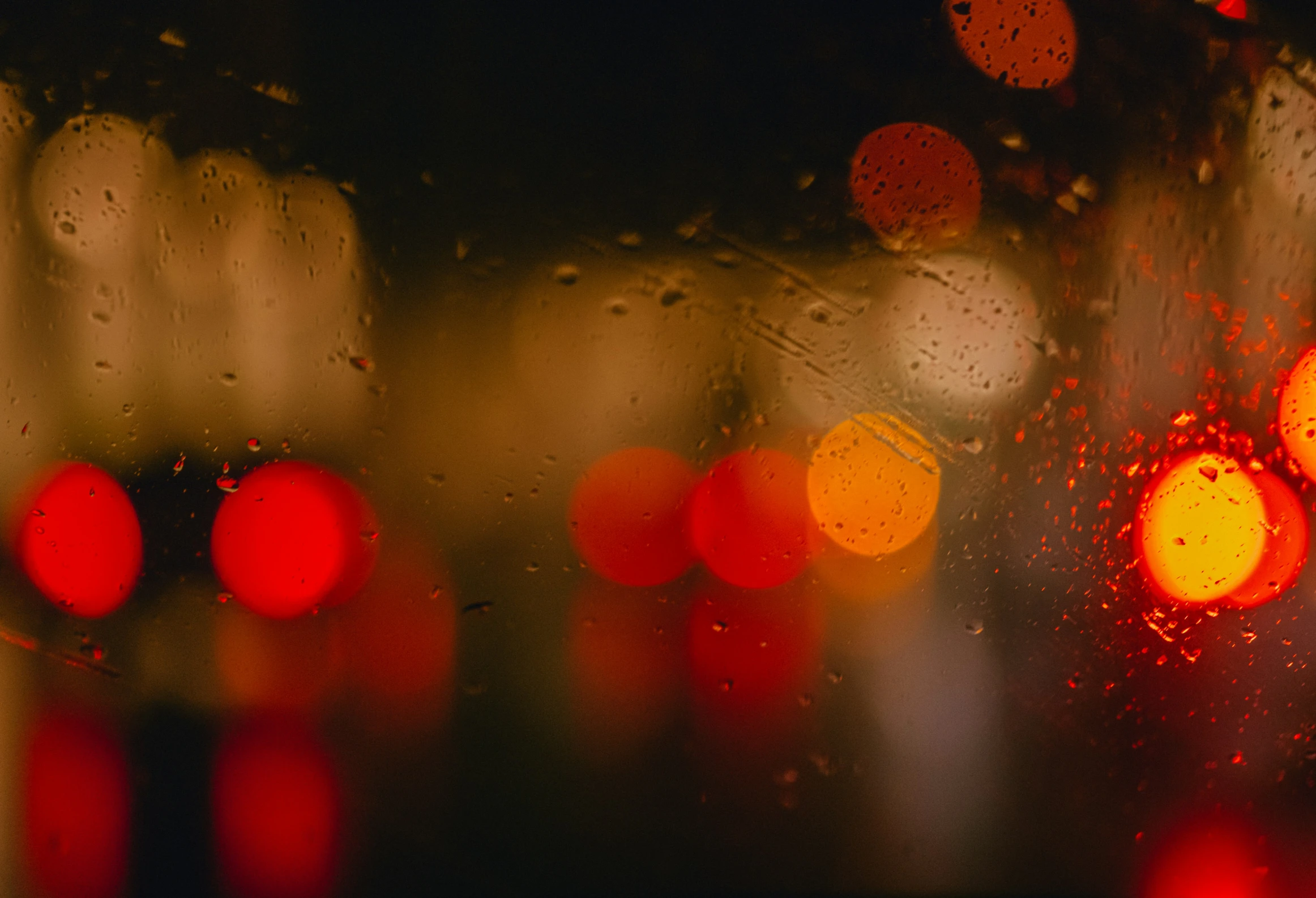 a close up view of some traffic lights and a wet window