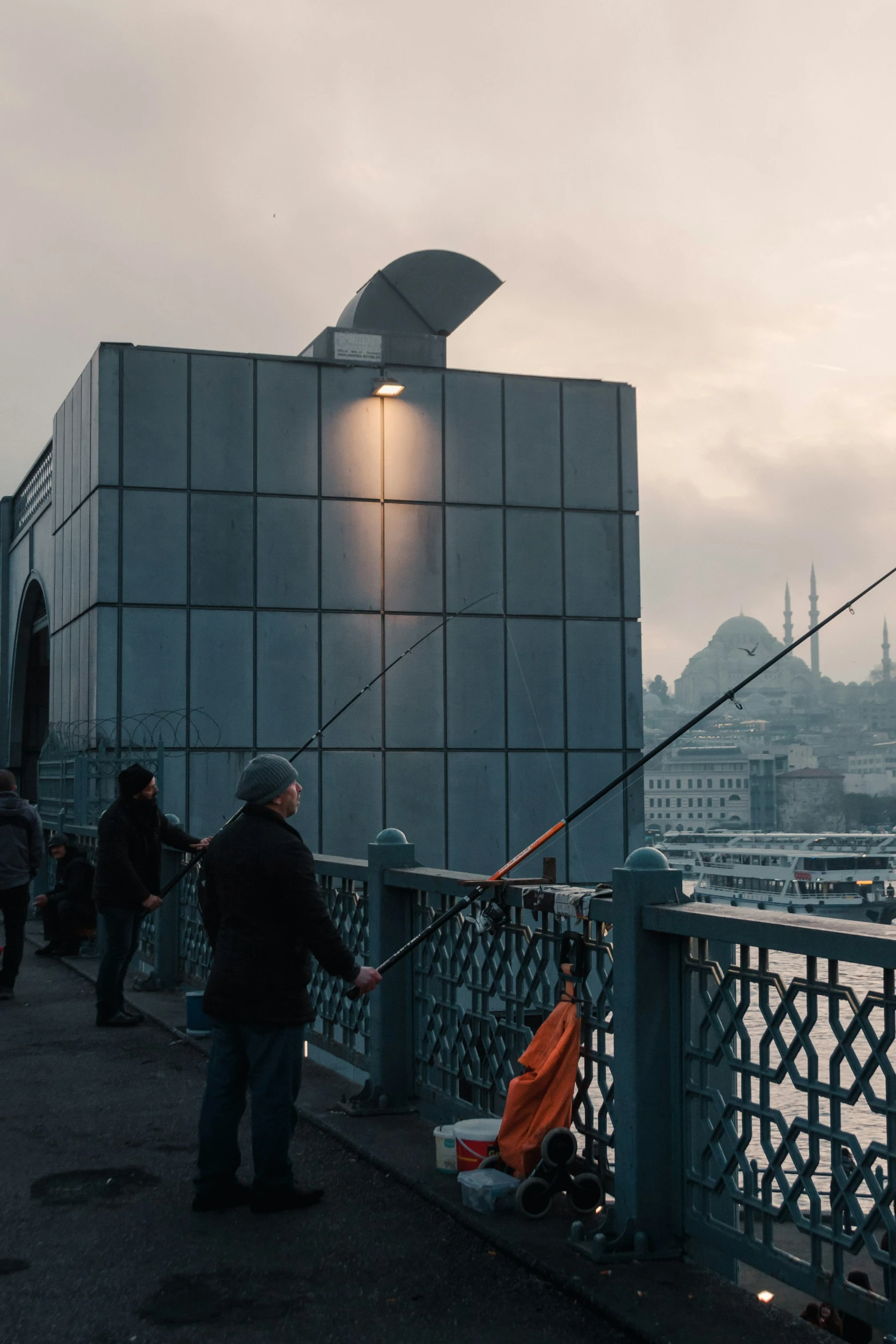 two people fishing from a pier in the evening