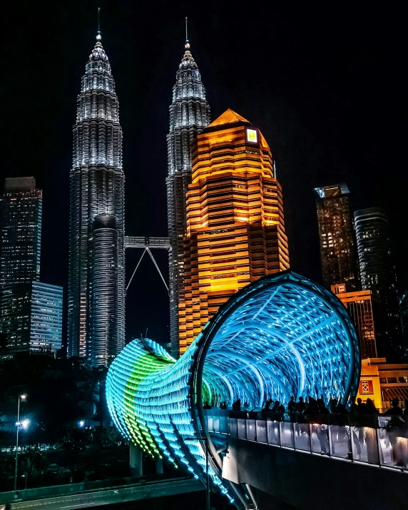 a very tall building sitting next to a lush green forest