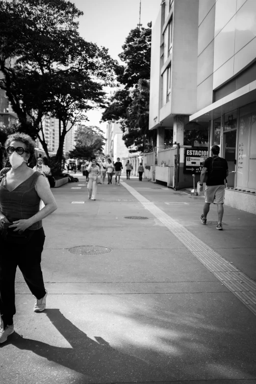 a woman standing in the middle of a street wearing mask