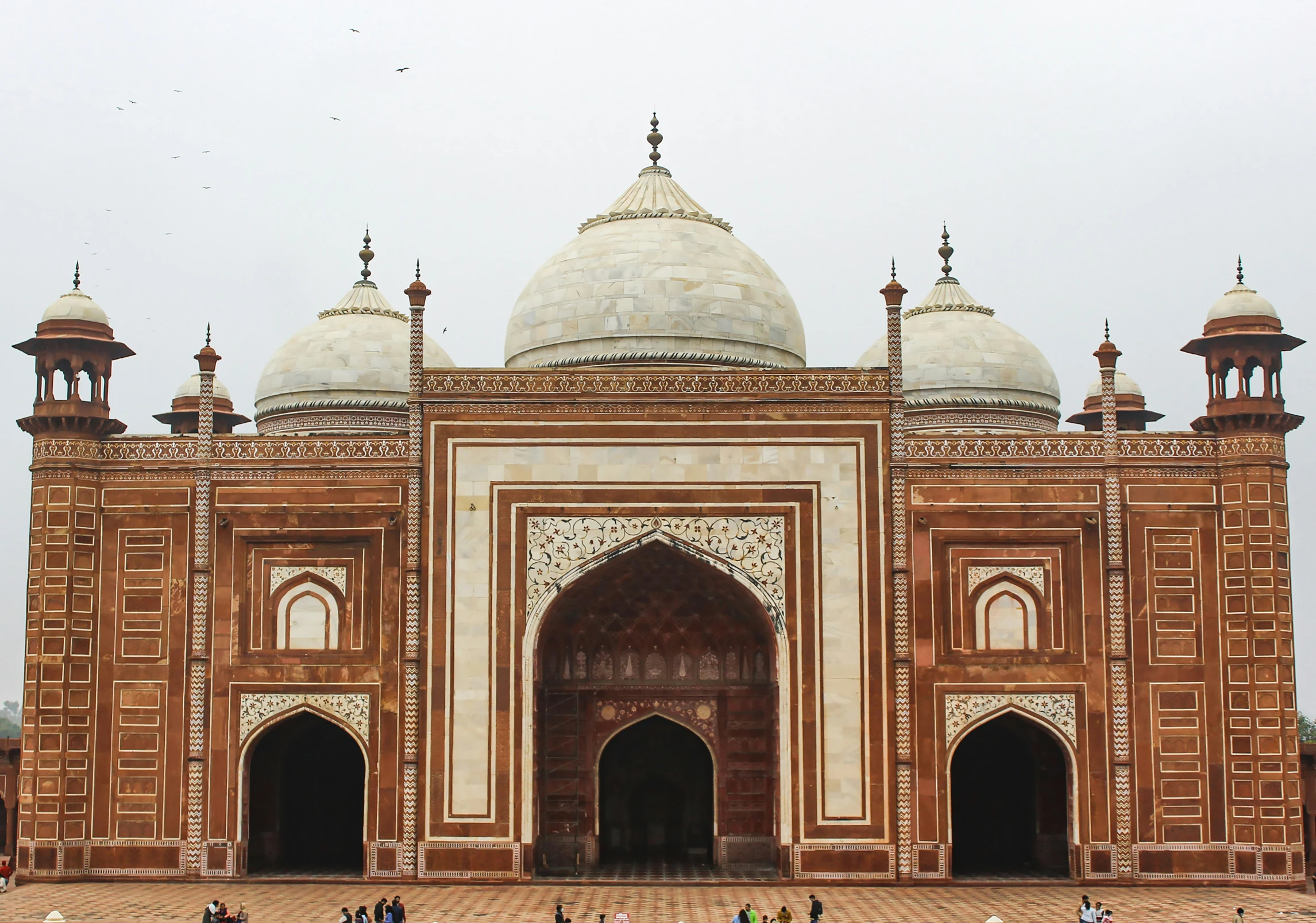 some people stand around a very large and ornate building