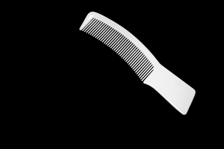 a large white comb on top of a black background