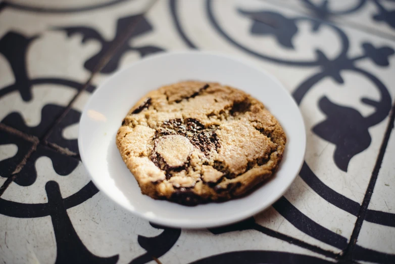 a large chocolate chip cookie on a white plate