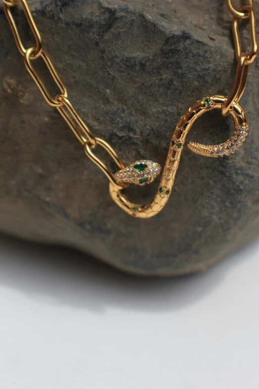 a closeup of a gold and green snake necklace