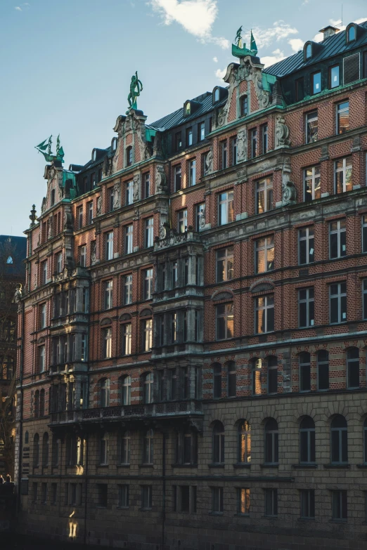 a very tall brown building with green roof tops