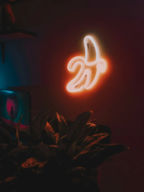 a neon sign on a wall in front of a large tv