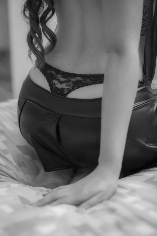 a women in a underwear on a bed looking down