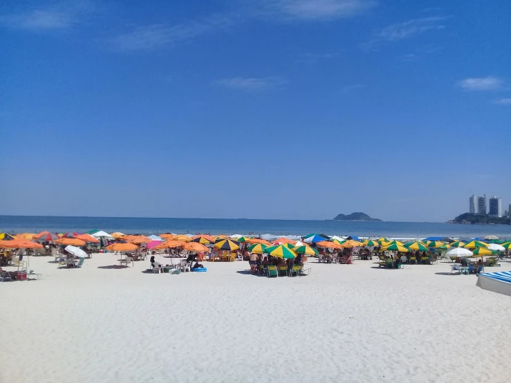 many colorful umbrellas are set up at the beach