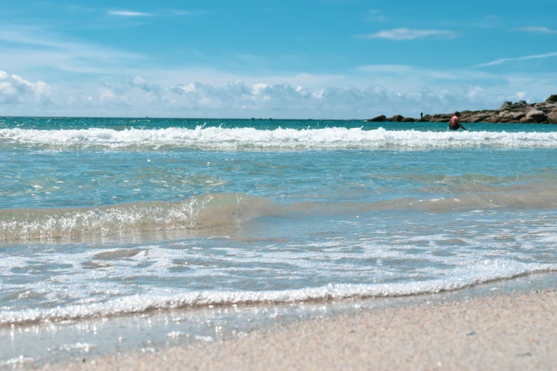 someone riding a horse in the water next to a beach