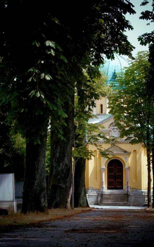 a big yellow church surrounded by some trees