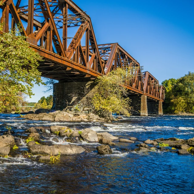 the old railway bridge is above the rushing river