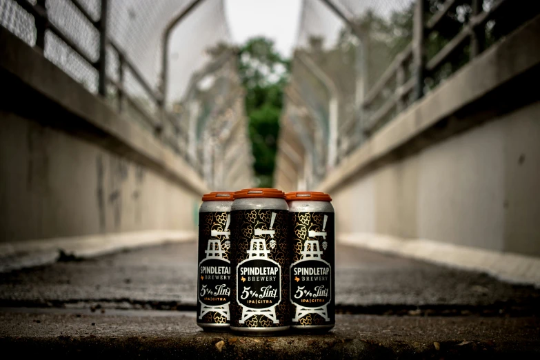 two different types of beer on pavement near cement bridge