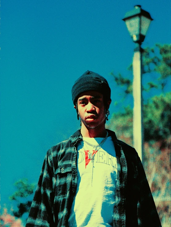 man wearing a jacket standing next to a pole