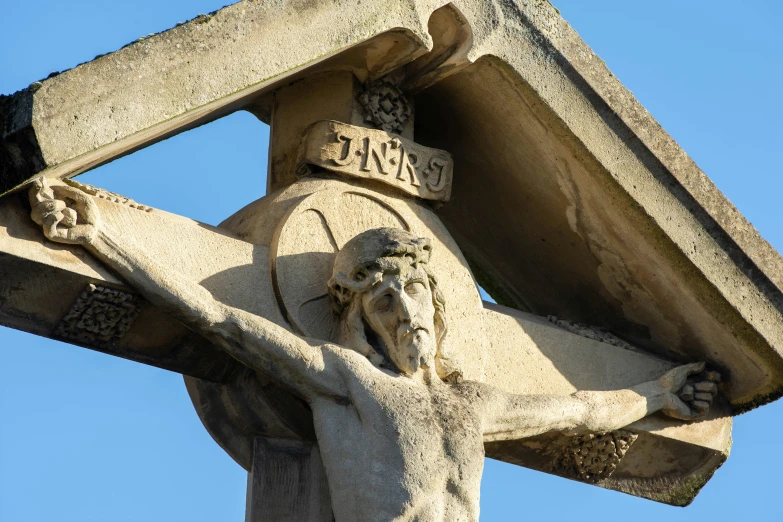 the statue has his cross raised in order to help him