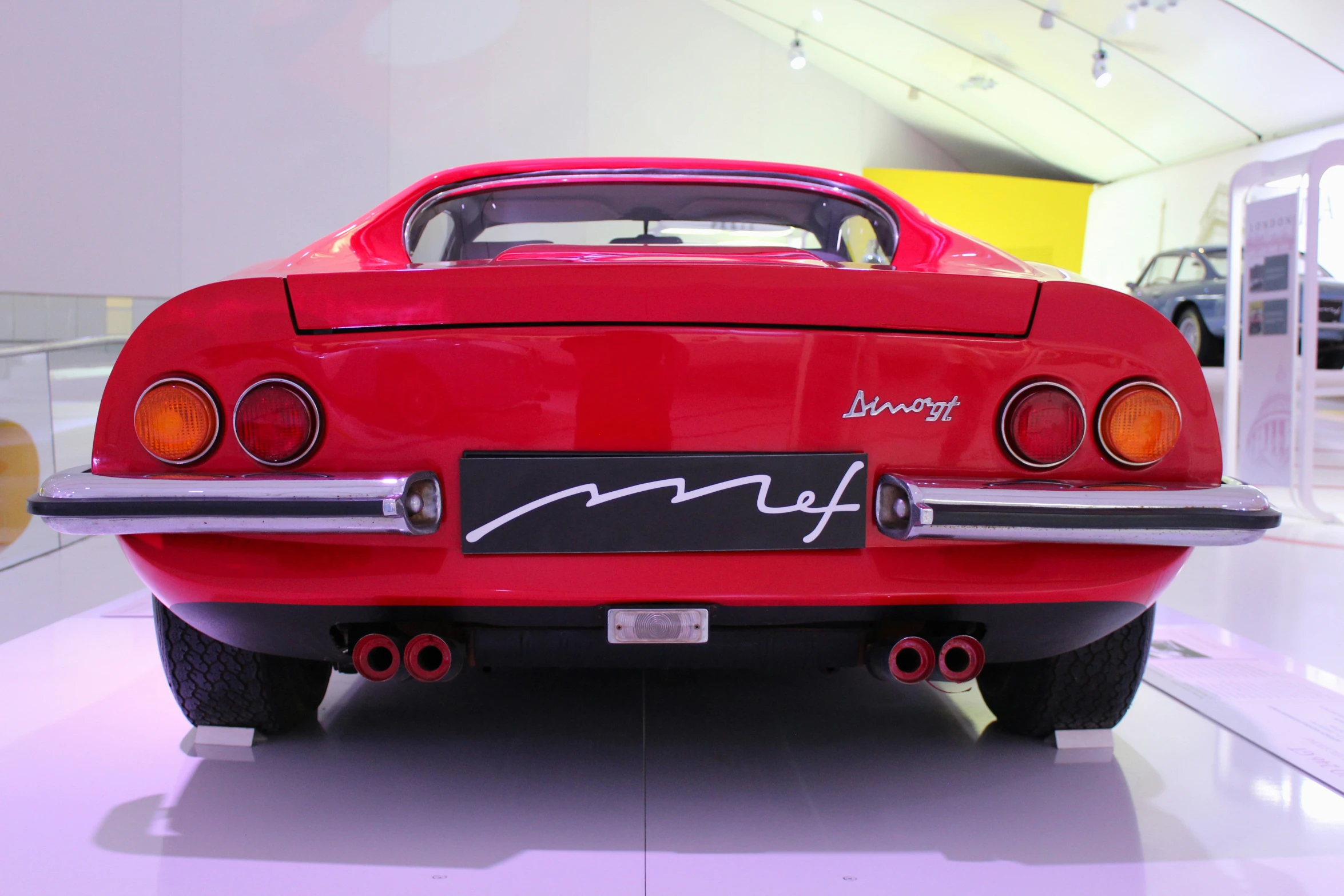 an old fashioned red sports car is on display