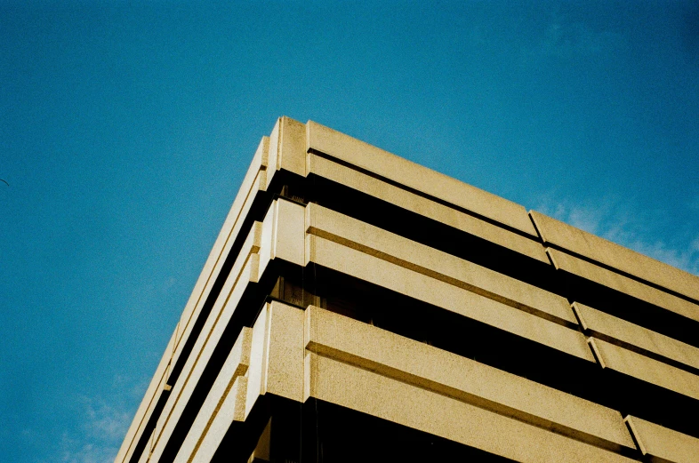 a stop light on a high building with the blue sky in the background