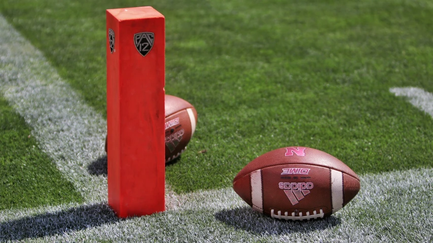 two footballs, one with a flag on the ground