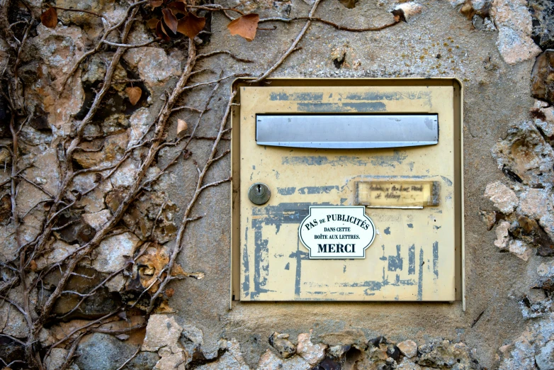 a yellow box attached to a stone wall