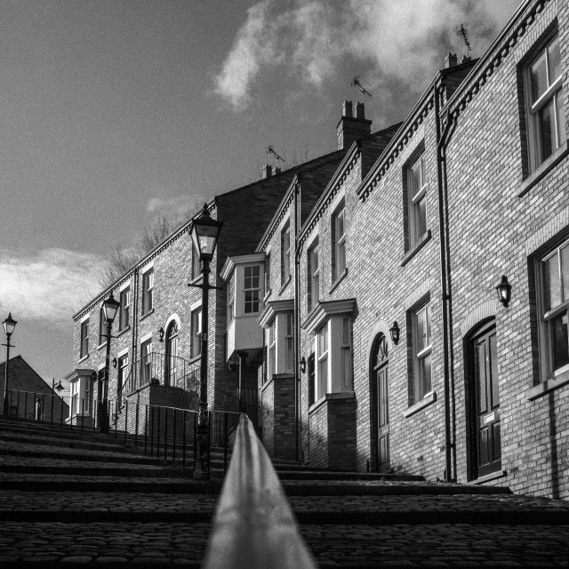 black and white pograph of steps next to brick buildings